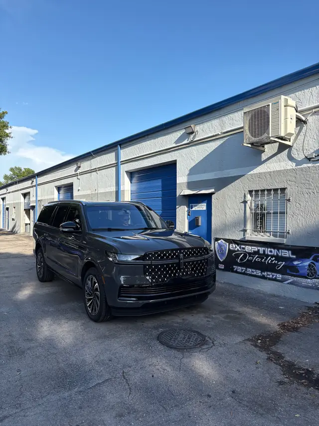 Black Lincoln Navigator parked in front of the shop under the Exceptional Detailing banner