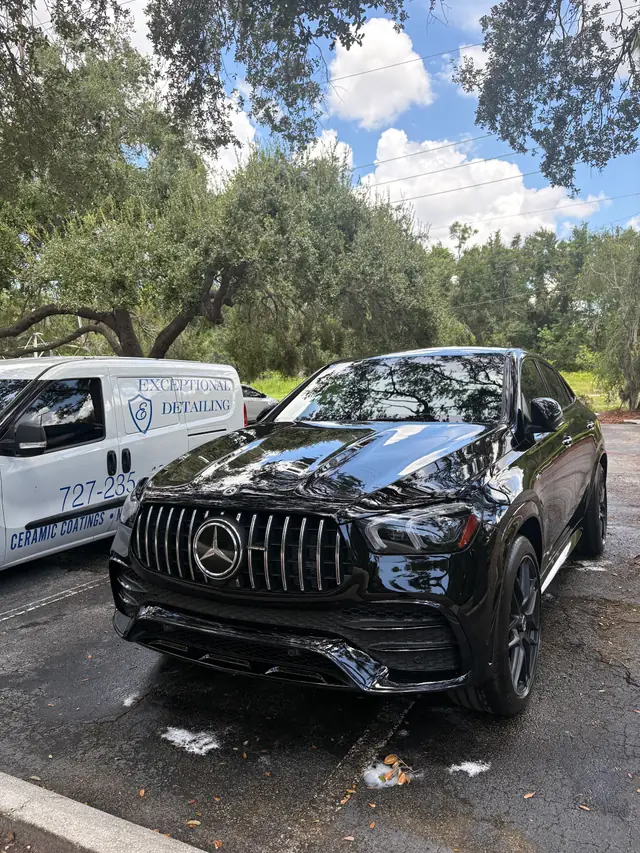 Black Mercedes-AMG GLE coupe parked beside the white Exceptional Detailing van lettered Ceramic Coatings