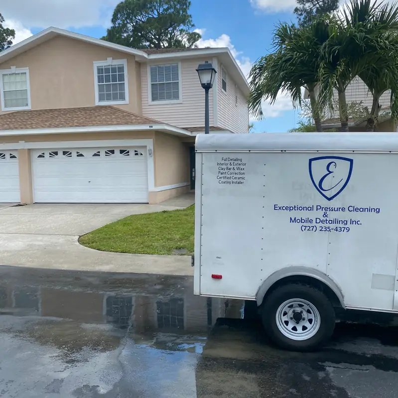 The company trailer in its own vinyl wrap, blue shield emblem and service list on white